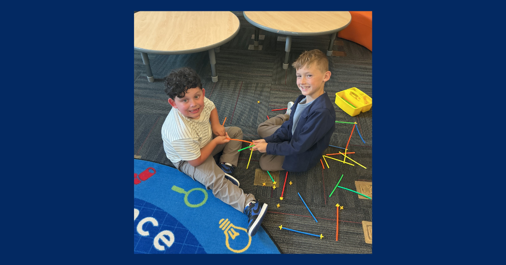 two students colobrating on a STEAM project and smiling