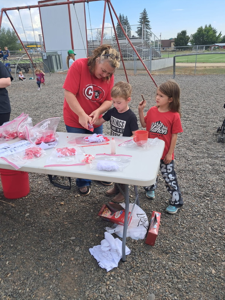 teacher helps students tie dye