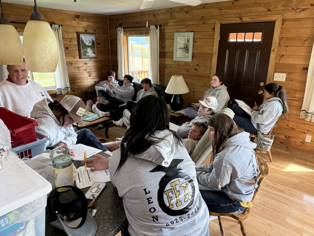 students in sweatshirts sit in a living room