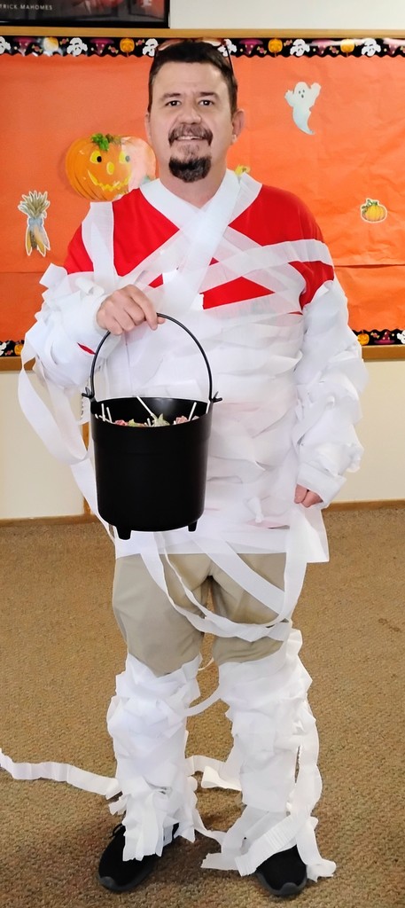 Man dressed as mummy holds Halloween bucket