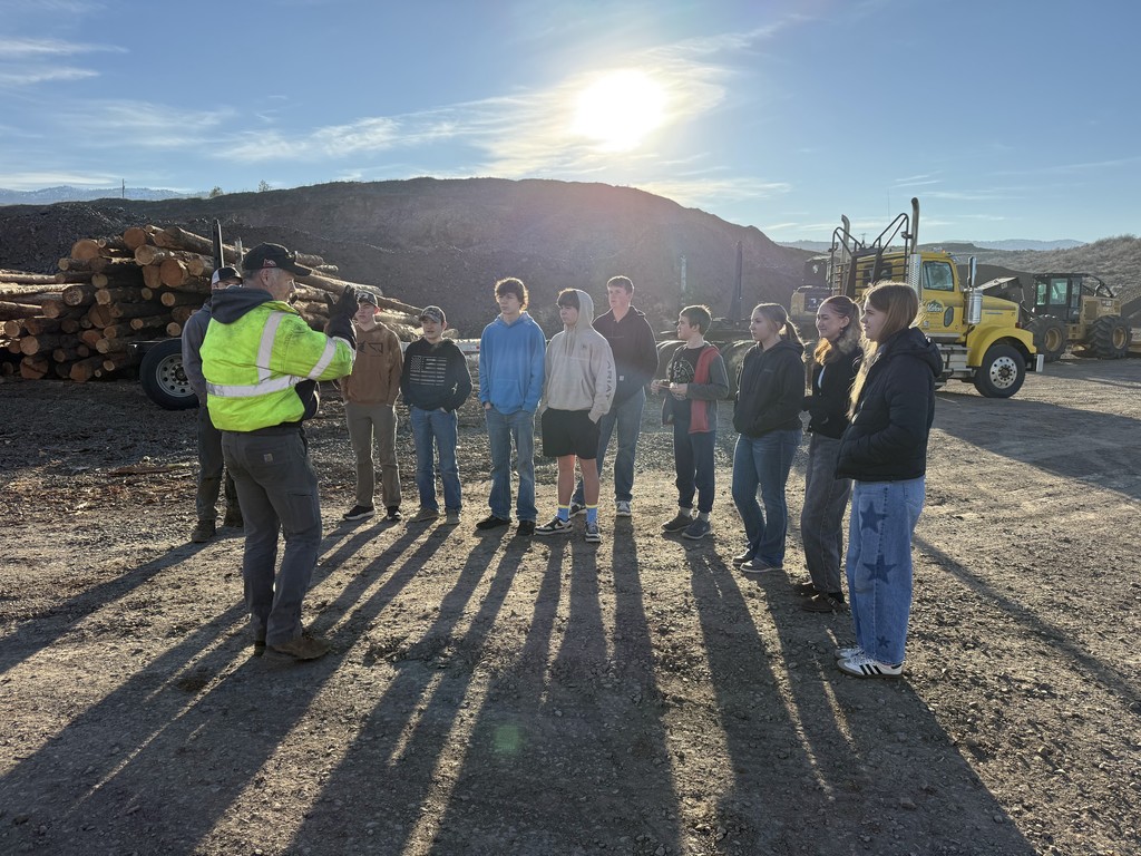 students listen to man in safety jacket