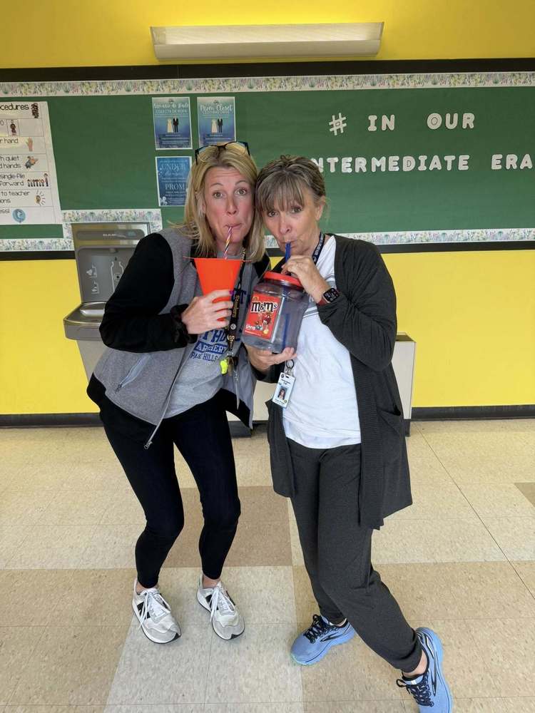 two teachers drink out of containers
