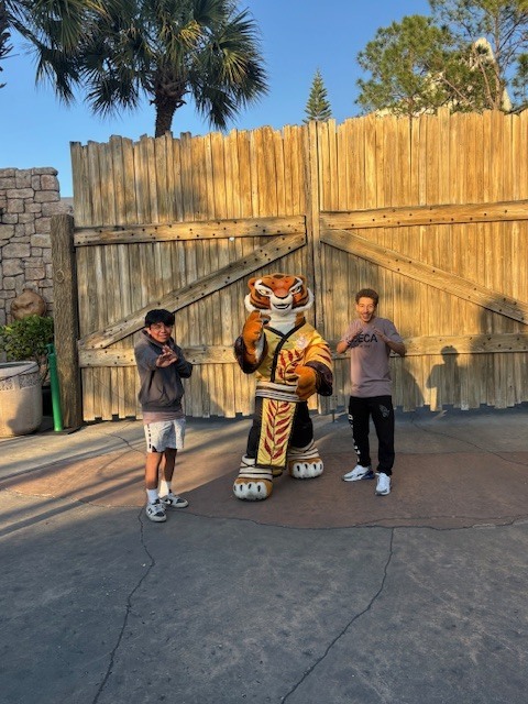DECA students posing with Mascot Master Tigress from Kung Fu Panda in Universal Studios