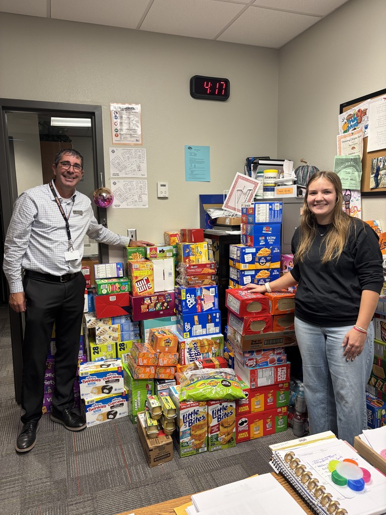 Haylee Gibson poses with Mr. Collins and the food donations she gathered and donated to our students in need