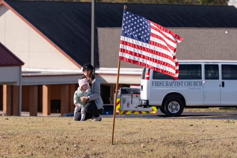 vTeacher and students at a parade with signs and flags
