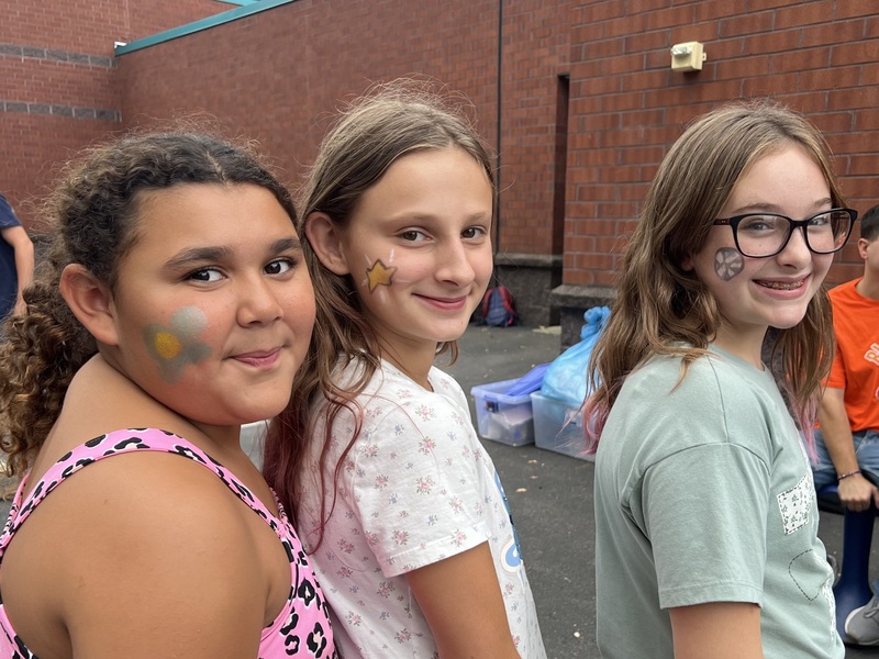 3 students showing off their face paint