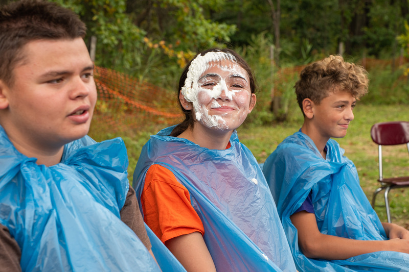 student with whip cream all over face