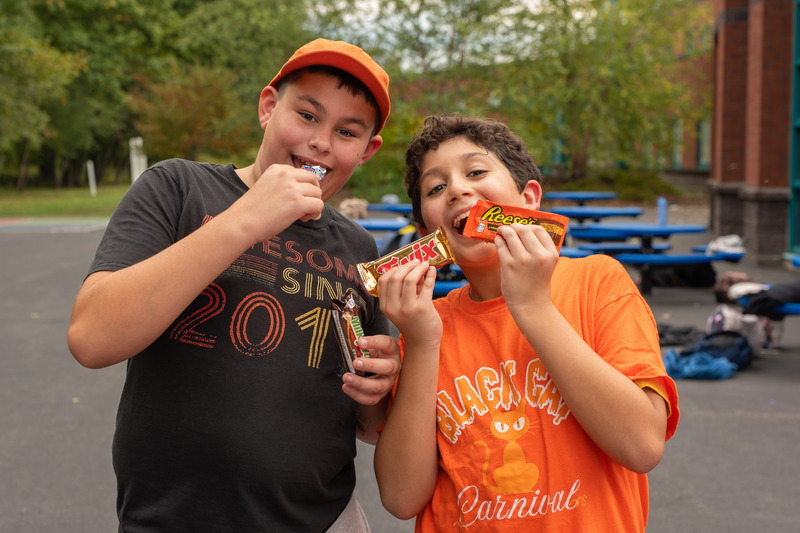 2 students showing off their candy prizes