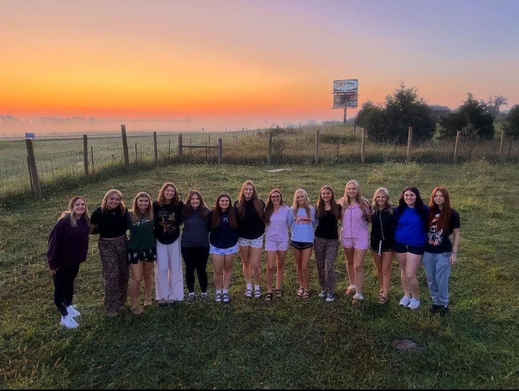 group of senior girls standing outside at sunrise