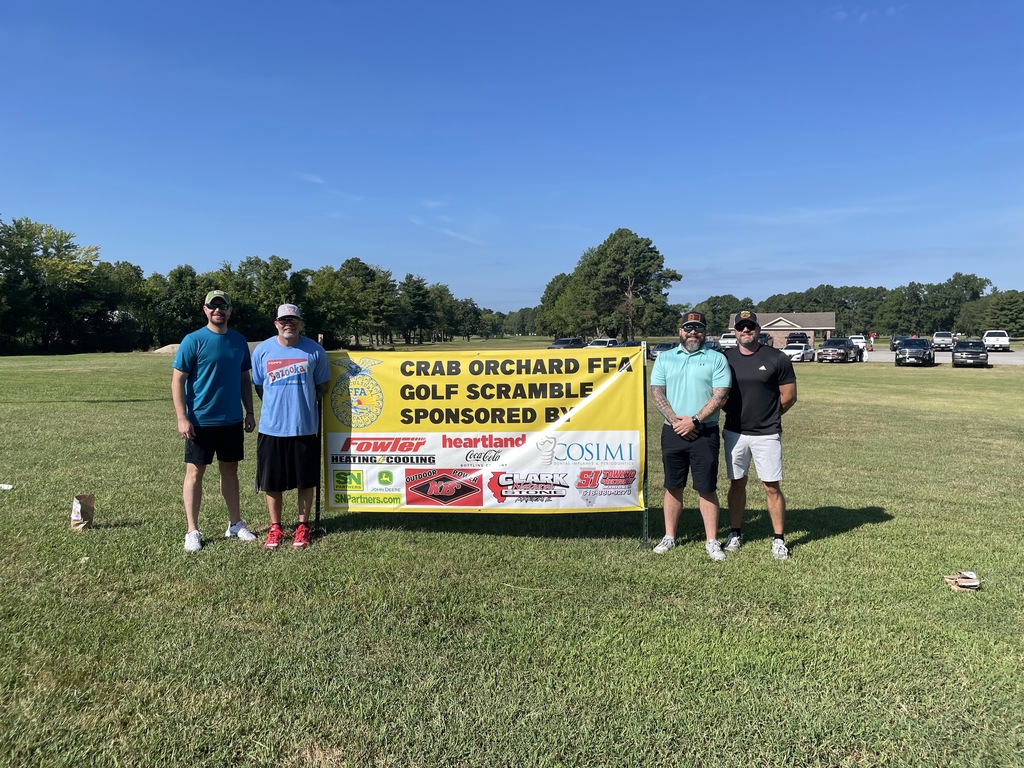 Men standing in front of a Golf Scramble sign