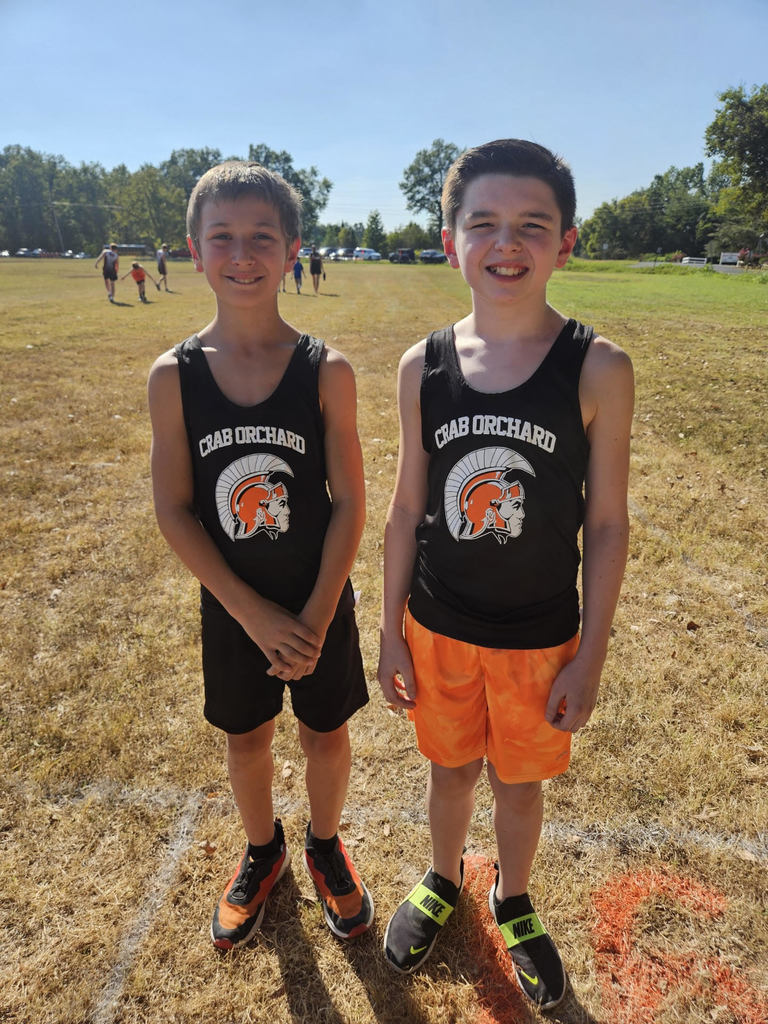 2 junior high cross country males wearing black and orange