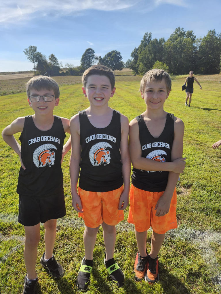 3 male junior high cross country students wearing orange and black