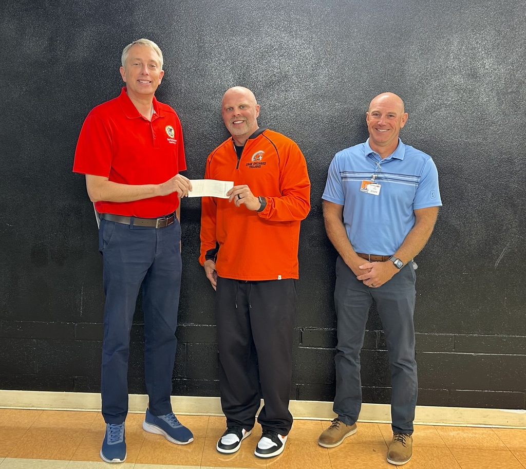 3 men standing in picture with from let to right taller man with red shirt coach with orange shirt and man with blue shirt