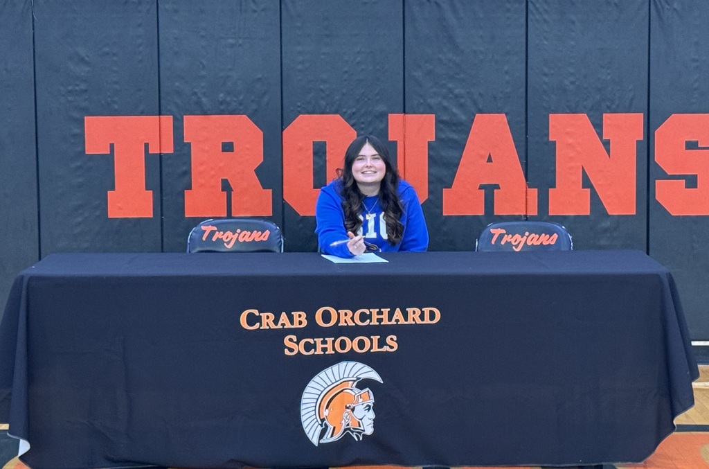 Player by herself signing her scholarship 