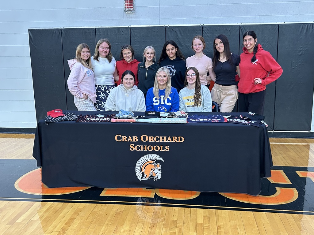 Softball players behind black table cloth