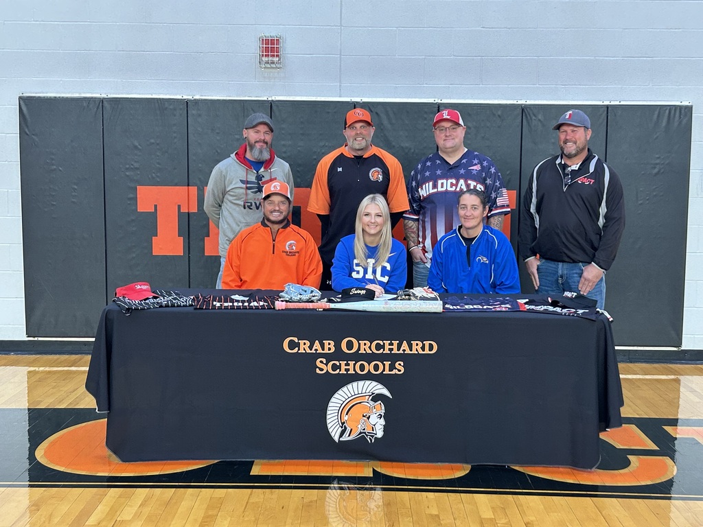 Group of coaches behind black tablecloth 