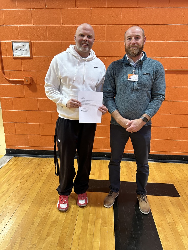 Teacher in white shirt holding letter, teacher in grey shirt holding letter