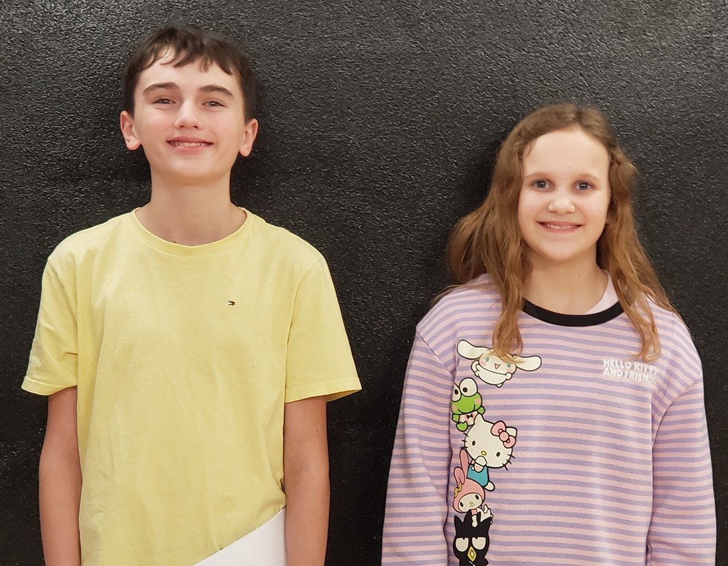 smiling girl with light brown hair wearing a pink & purple striped sweatshirt with animals on it standing by a smiling boy wearing a yellow t-shirt