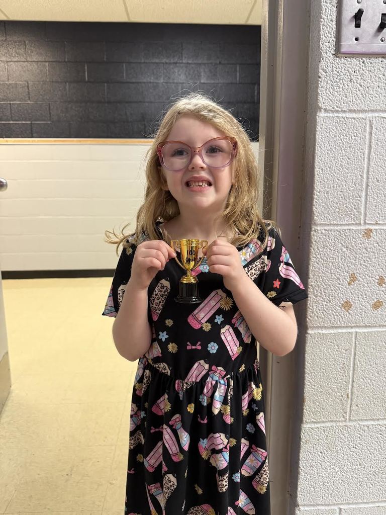 Kindergarten with blonde hair holding a plastic trophy