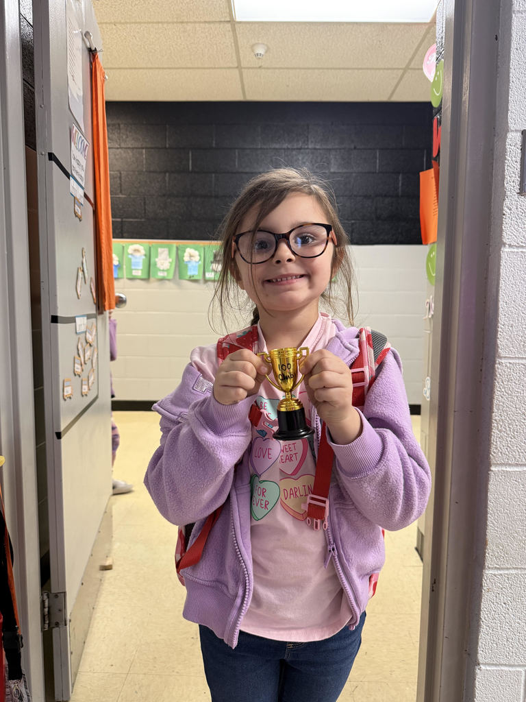 Kindergarten with brown hair holding a plastic trophy
