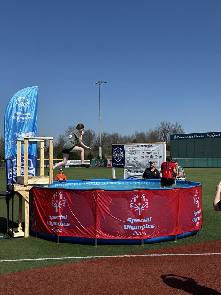 Student in grey shirt jumping in pool