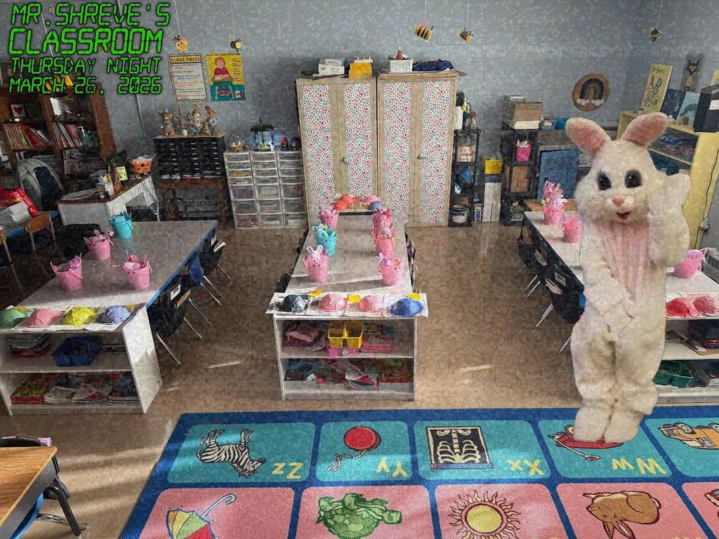 the easter bunny standing around 3 tables in a first grade classroom