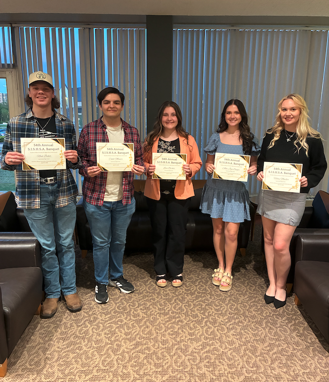 2 male and 3 high school females holding certificates standing in front of windows with vertical blinds