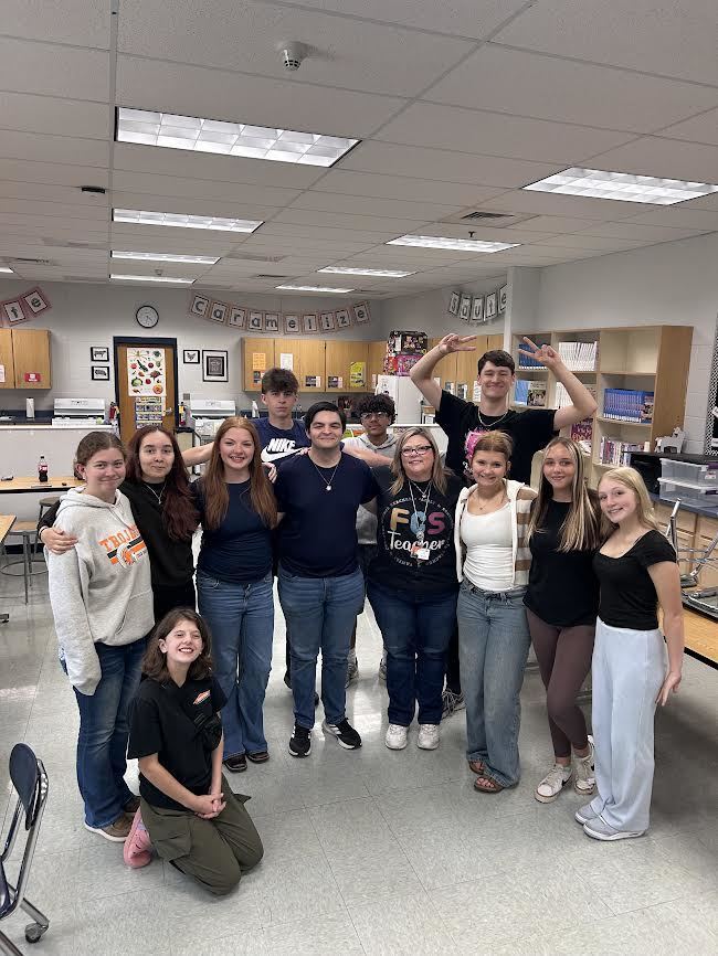 group of high school students with their FCCLA sponsor standing in a group in a classroom