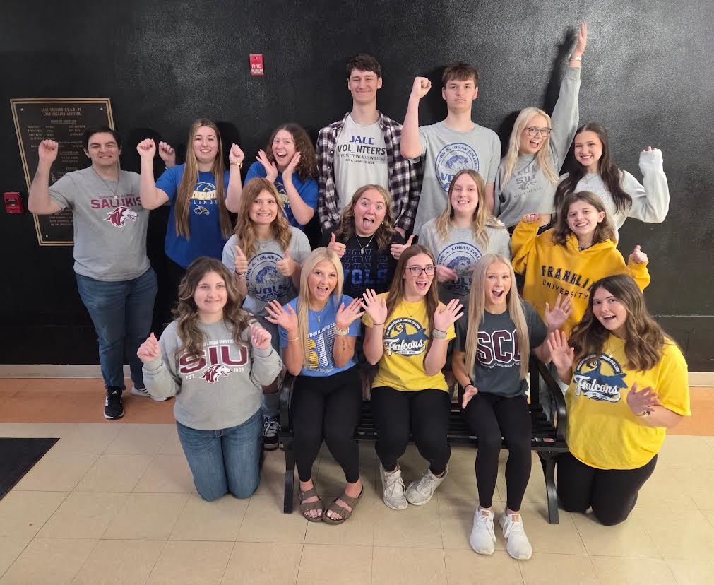 college seniors posing in a hallway making silly faces with their future college on their shirt