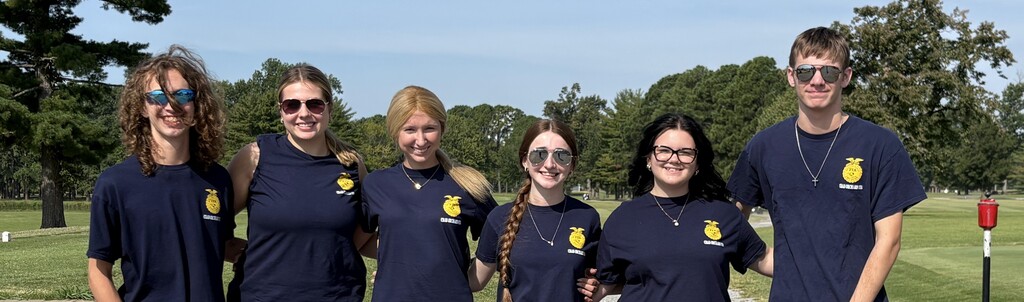4 young ladies and 2 young men in navy FFA t-shirts standing on a golf course