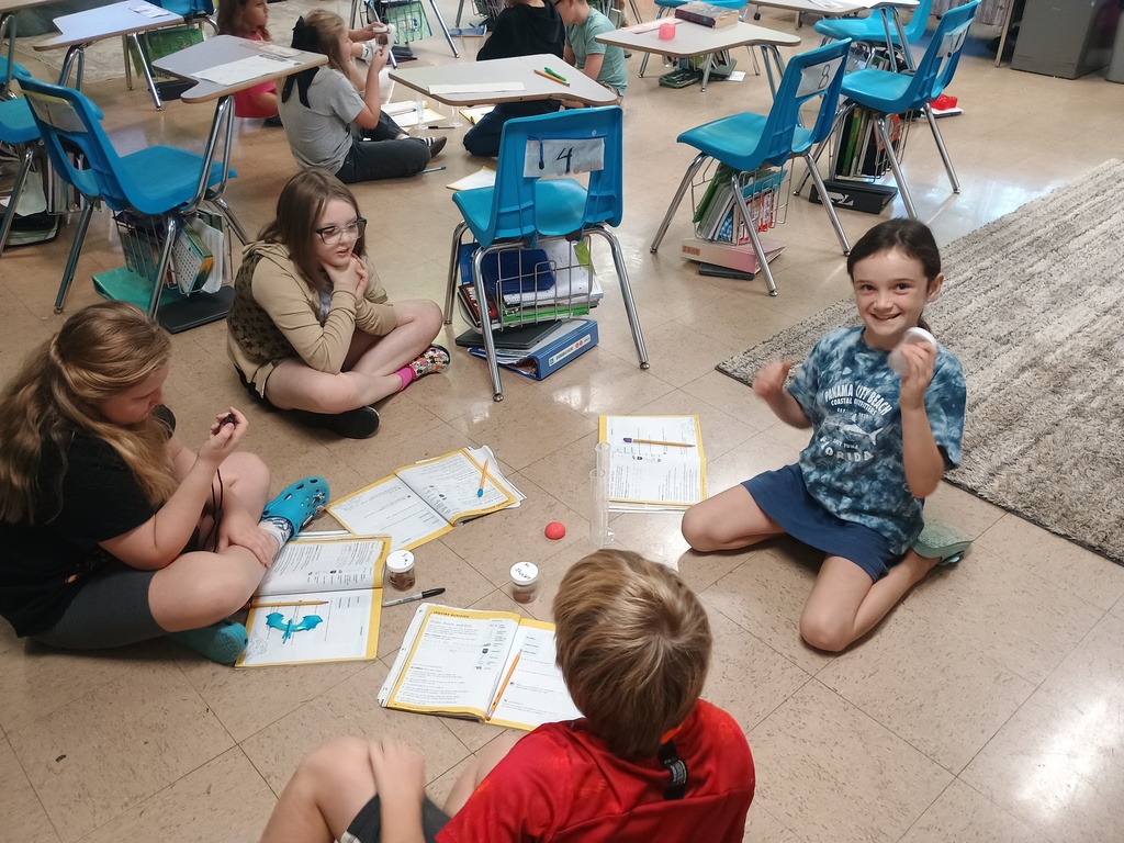 4th grade students, sitting on the floor in groups, doing an erosion activity