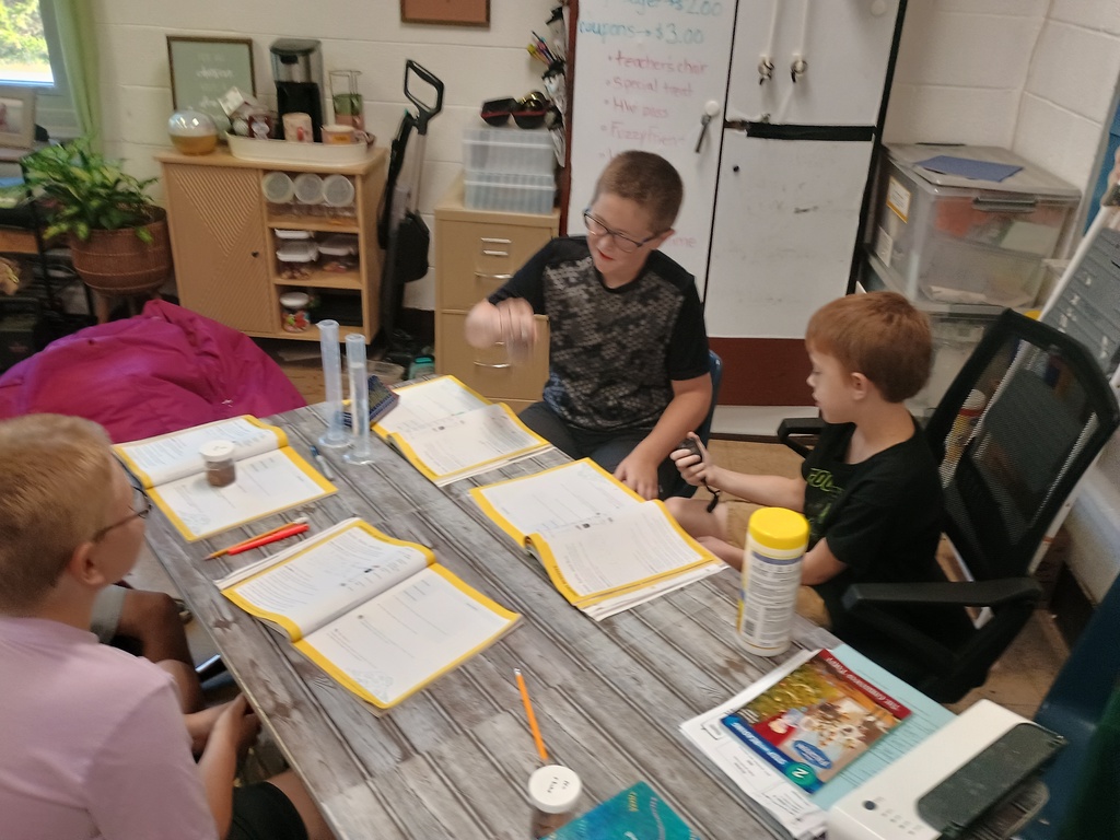 4th grade students sitting at a table with papers in front of them