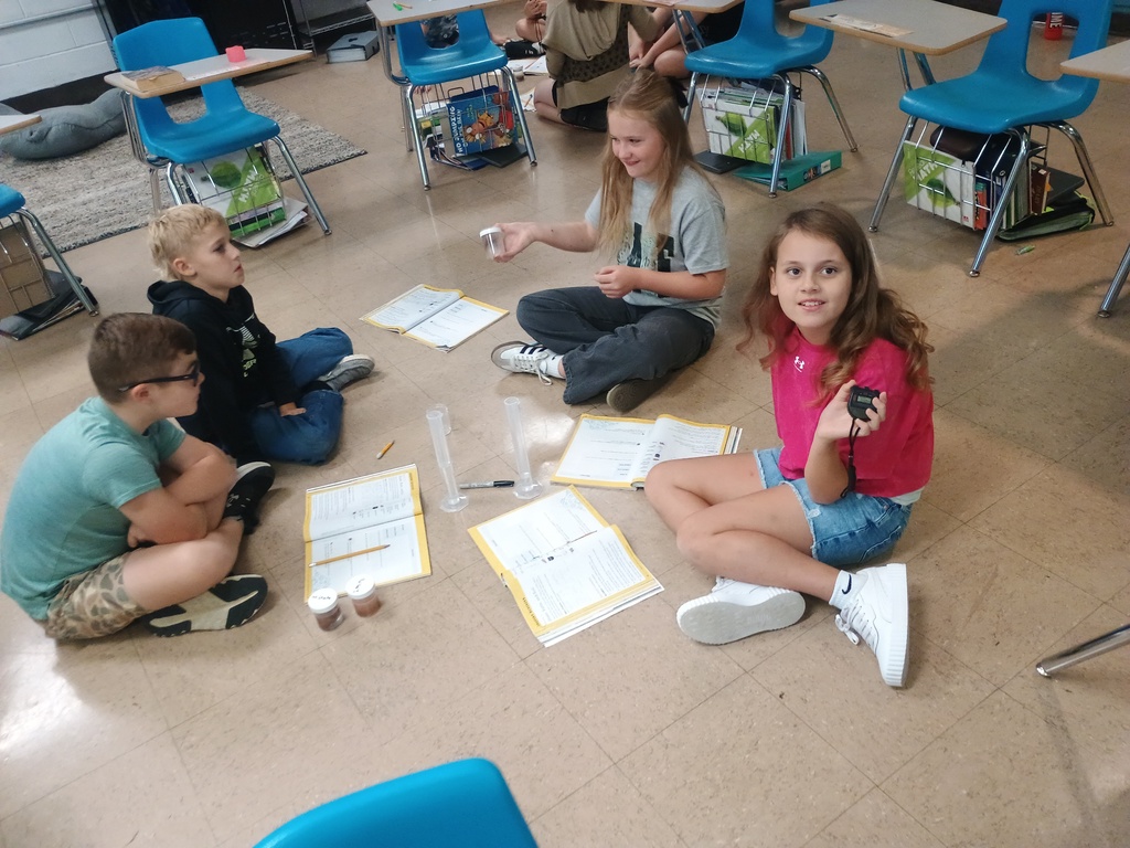 4th grade students sitting on the floor working on an erosion project