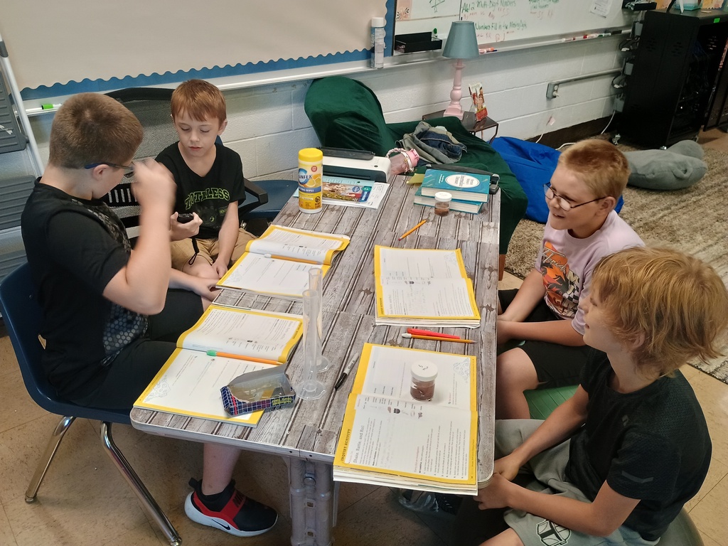 4th grade students sitting at a table doing group work sitting at a table