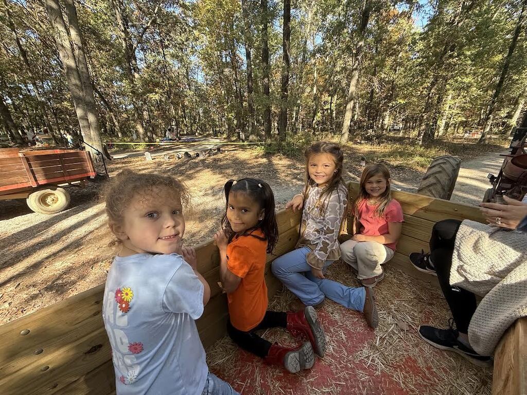 kindergarten students sitting in a wagon at a pumpkin patch