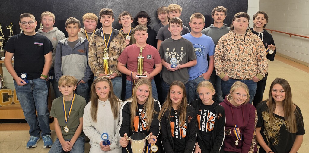 large group of male and female junior high and high school students holding trophies and medals