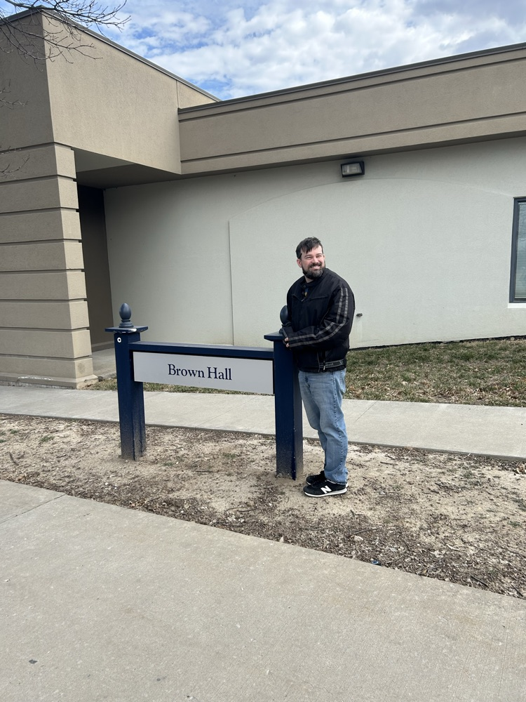 Mr. Brown in front of Brown Hall