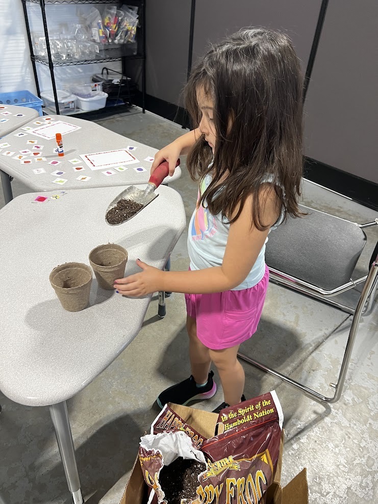 Scholar filling pots of dirt