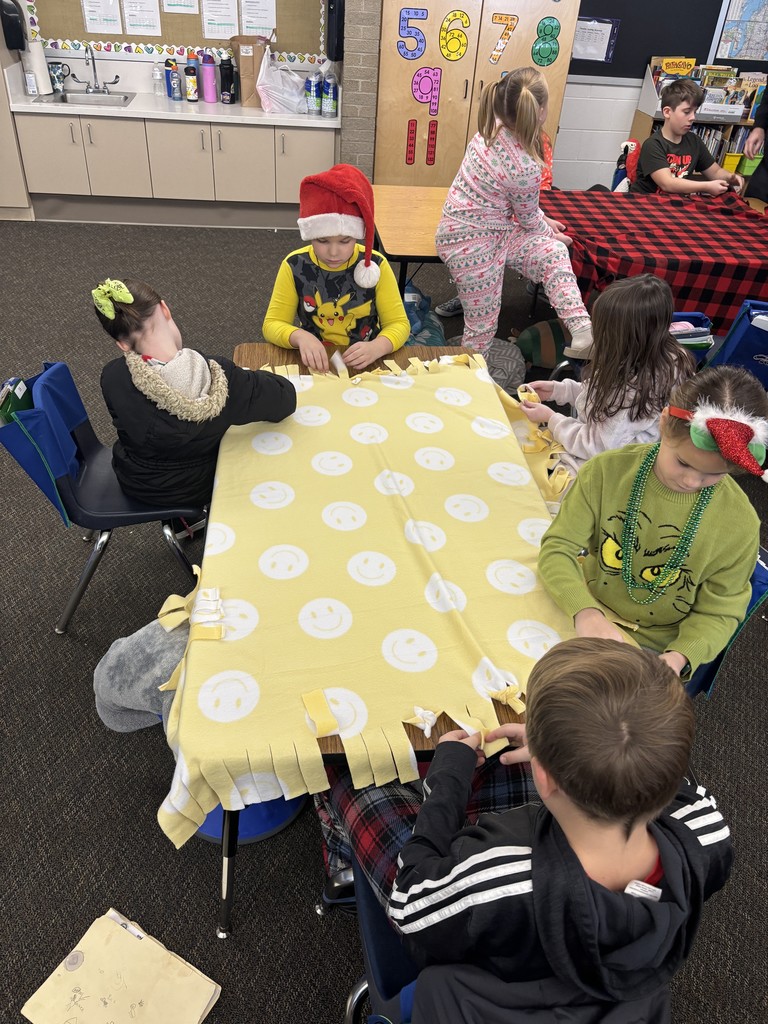 3rd grade students making tie blankets for their "giving celebration" 