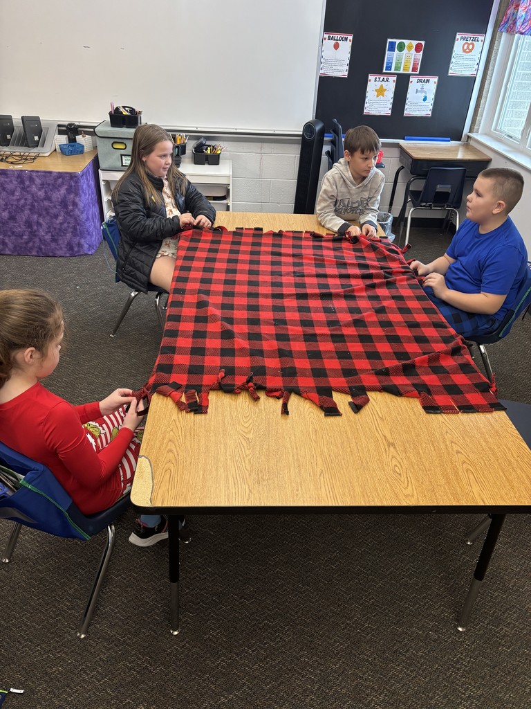3rd grade students making tie blankets for their "giving celebration" 