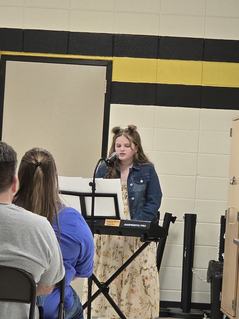 Kathryn playing keyboard and singing.