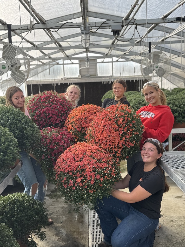 students holding mums that are for sale at CCMHS