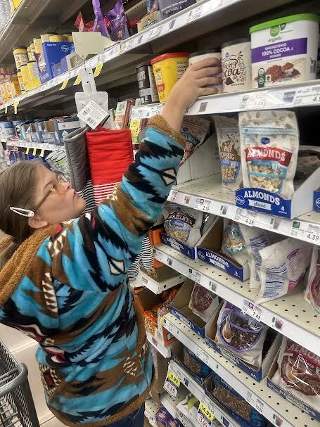 student selecting items from a shelf at Kroger