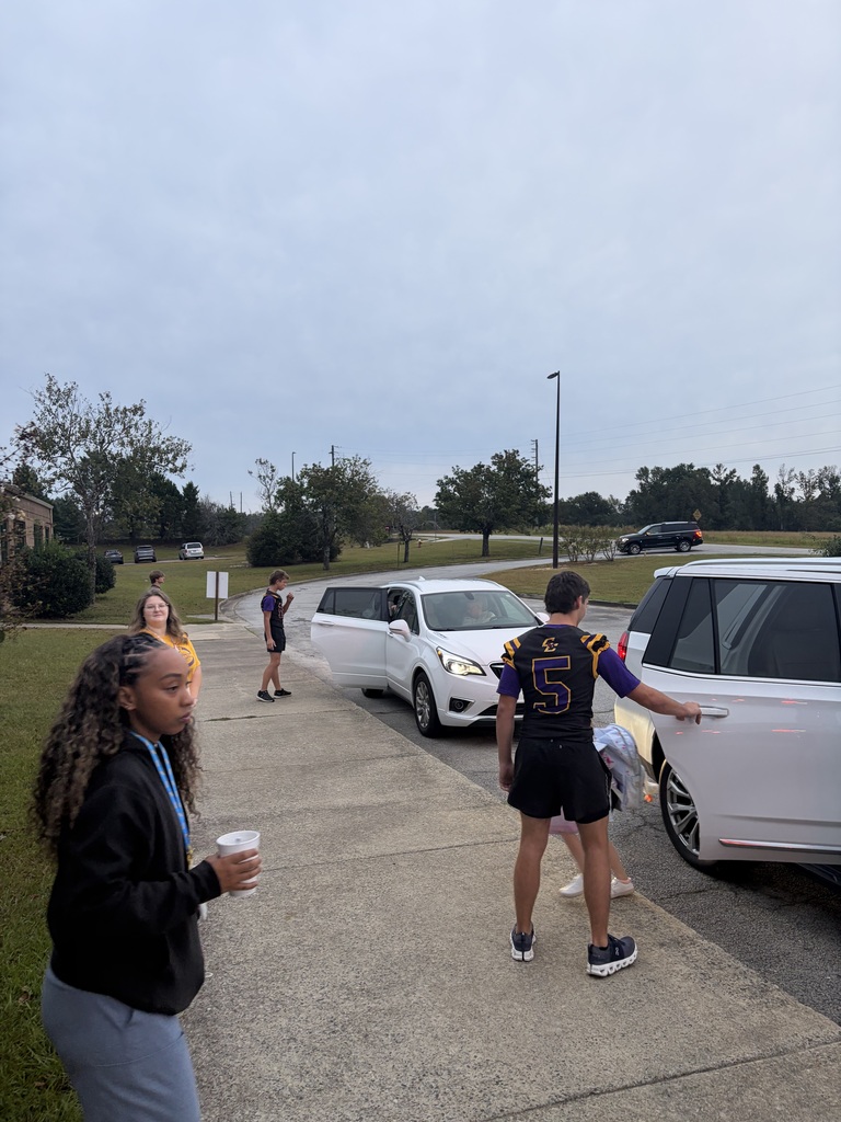 football players greeting students in the drop-off line