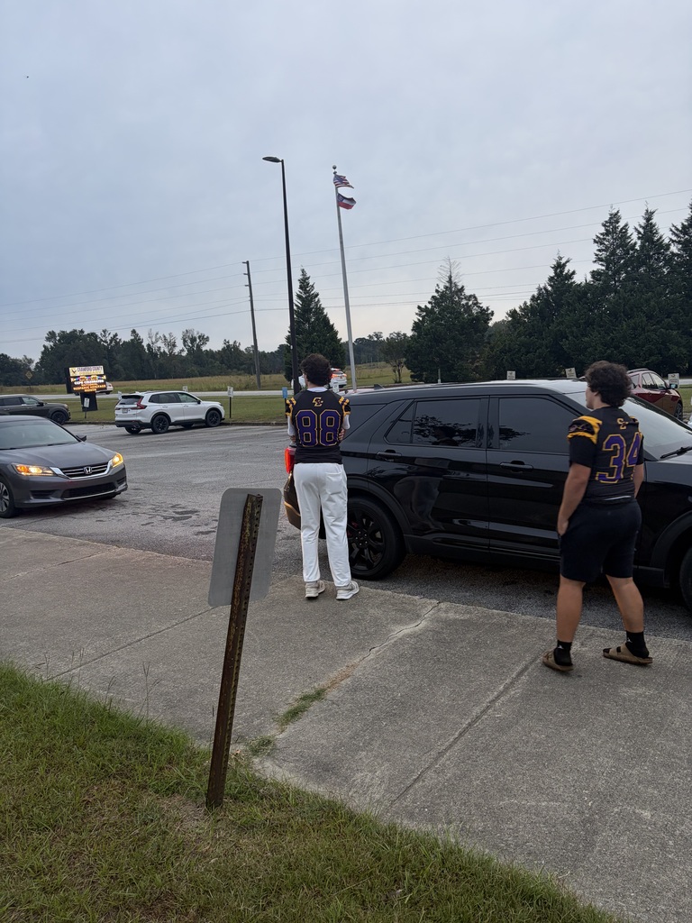 football players greeting students in the drop-off line