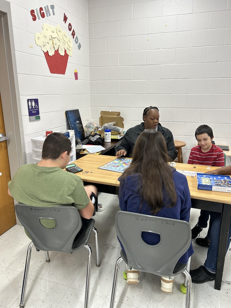 students and teacher playing a board game