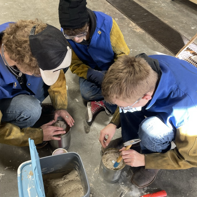 students filling buckets with sand