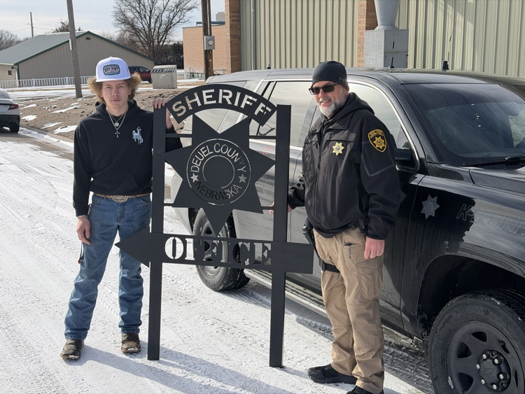 custom sign posted in front of sheriffs vehicle with student and sheriff  