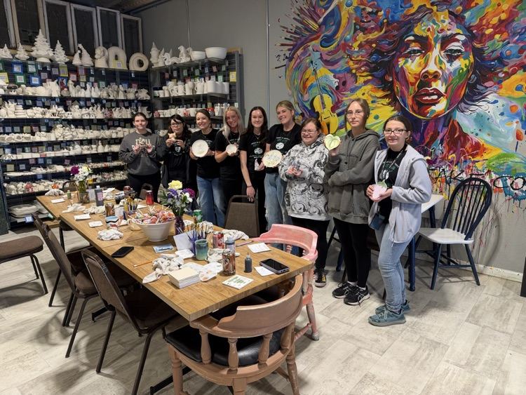 group showing their painted pottery 