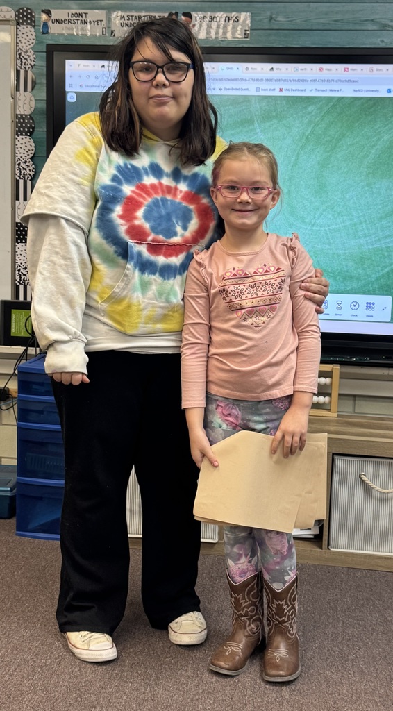 Big smiles from our seniors and second graders showing off their final piece of writing.